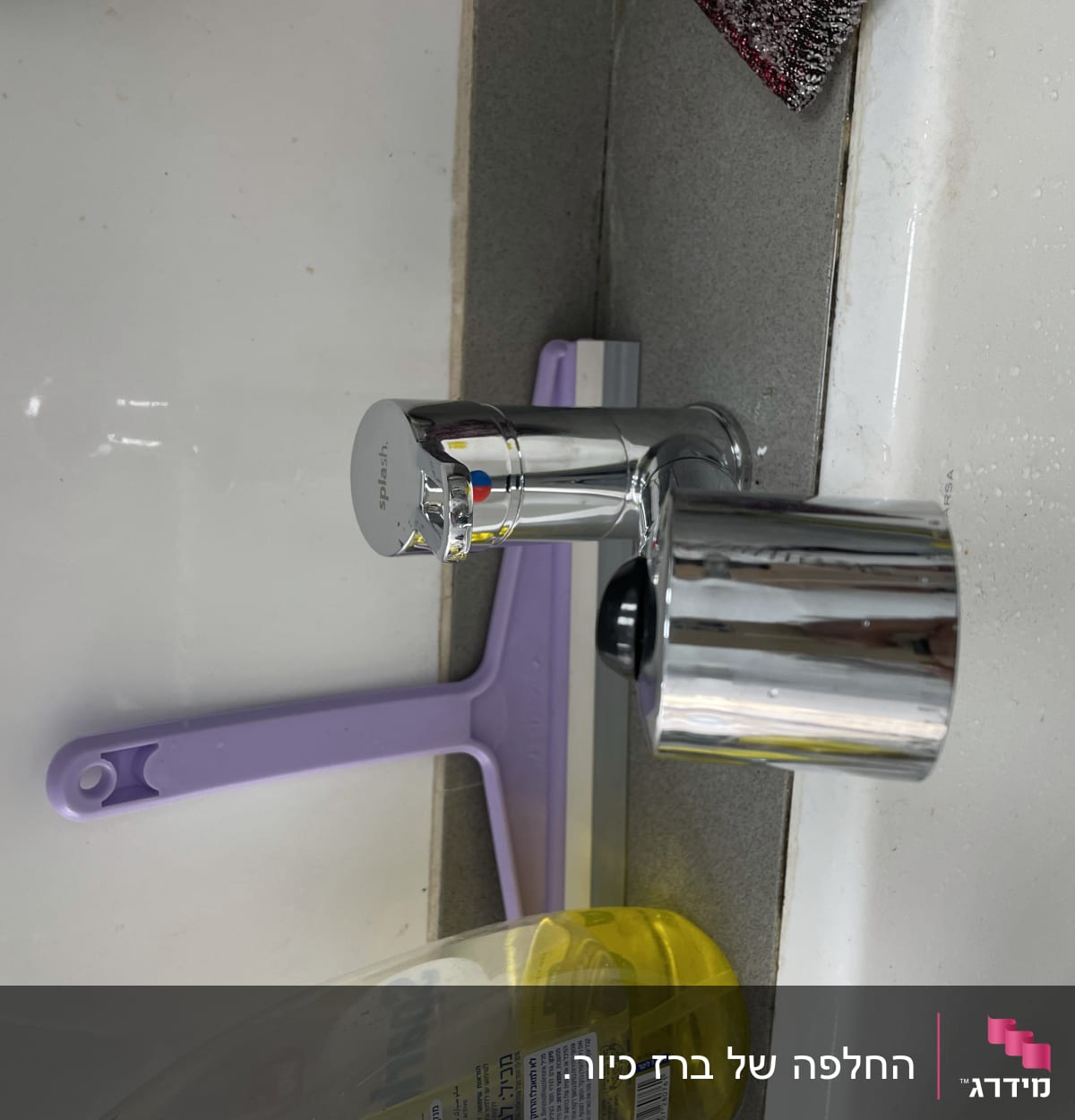 ברז כרום עם ידית סגולה ליד כיור